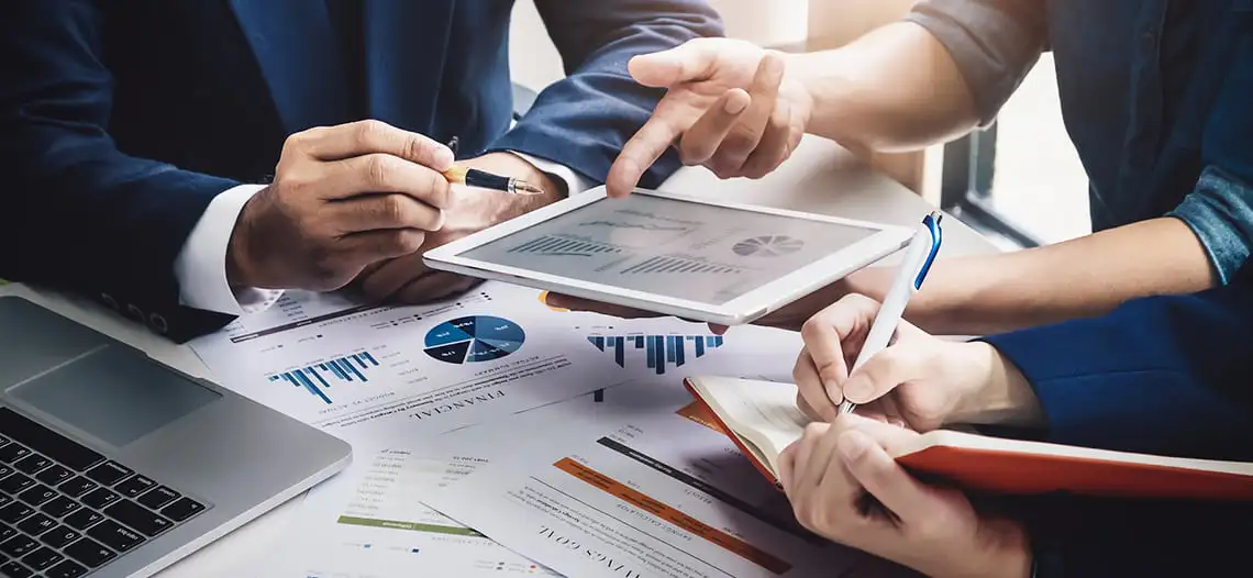 Equipe analisando gráficos e estratégias para aumentar o volume de vendas da empresa