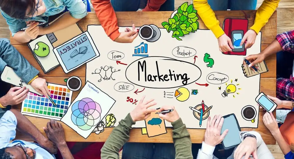 Profissionais montando um plano de marketing em quadro com etapas, metas e canais de divulgação